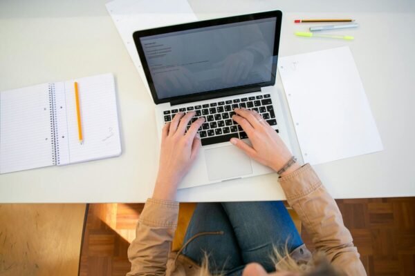 Student preparing for Pace University Algorithm Master final exam questions on a laptop at a clean desk with notebooks and pens